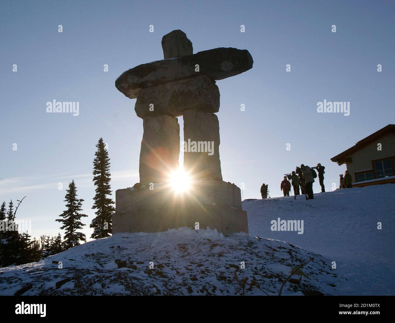 The sun rises between the legs of an Inukshuk atop Whistler Mountain in Whistler, British Columbia December 11, 2008. The Inukshuk is man made landmark used by the peoples of the North American Arctic as a navigation point. Whistler will be the site of the alpine and Nordic events of the 2010 Olympic Winter Games.   REUTERS/Andy Clark     (CANADA) Stock Photo