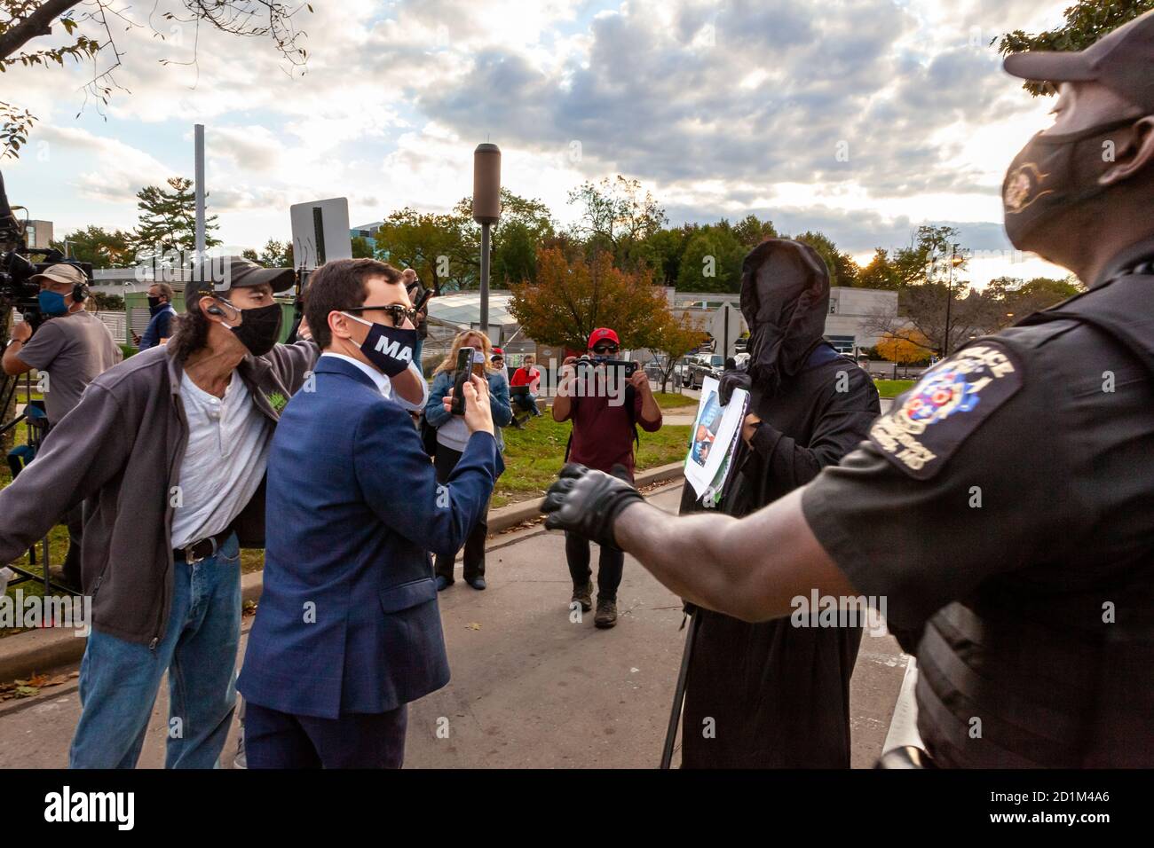 Bethesda, MD, USA, 5 October, 2020.  Pictured:  A Montgomery County Maryland police officer steps in to stop rapidly escalating verbal and physical aggression by Trump suporters against a man dressed as the Grim Reaper.  Trump supporters gathered outside Walter Reed National Military Medical Center where the President was hospitalized for covid-19 following infection by the novel coronavirus.  Credit: Allison C Bailey/Alamy Live News Stock Photo