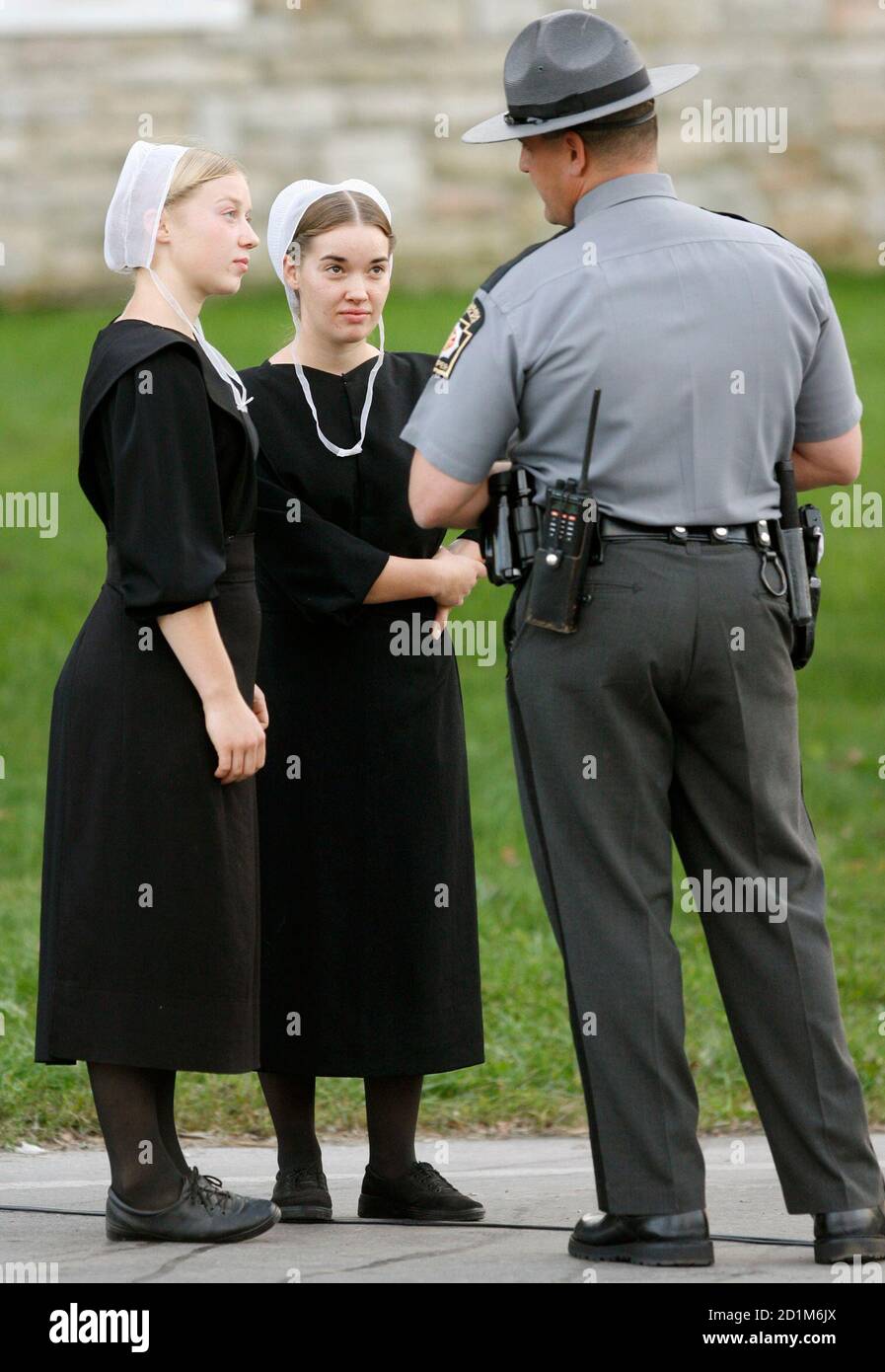 Amish girls talk to a state trooper at the scene of the