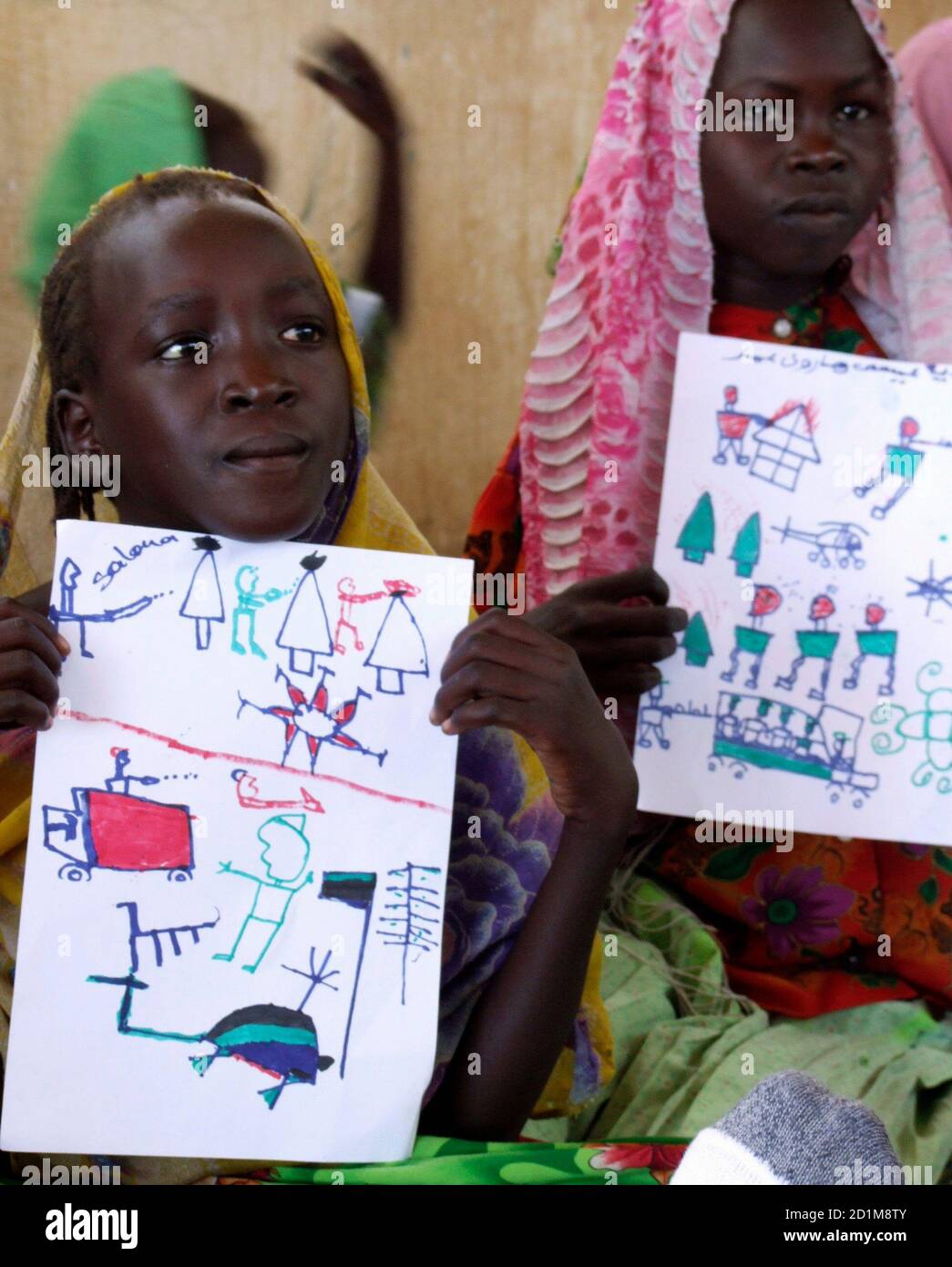 Refugee girls hold up drawings depicting Janjaweed attacks, in Djabal refugee camp, Goz Beida, eastern Chad, August 10, 2007. Most refugees appear to be under the impression that a UN force would be composed of Western troops, not the more likely scenario of African soldiers under a UN command. Picture taken August 10, 2007.   To match feature DARFUR-CHAD/REFUGEES     REUTERS/Stephanie Hancock (CHAD) Stock Photo
