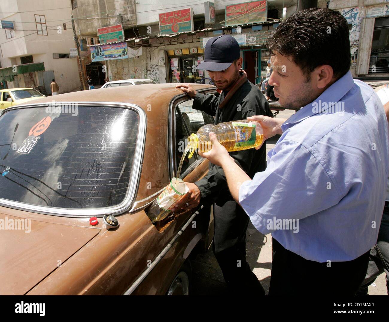 A Palestinian taxi driver fills his taxi with cooking oil in Gaza Strip April 30, 2008. Faced with chronic fuel shortages due to an Israeli blockade and a strike by Palestinian distributors protesting supply caps, taxi drivers in the Gaza Strip are filling their tanks with cooking oil, often scrounging leftover fat from street vendors. To match feature PALESTINIANS-ISRAEL/FUEL REUTERS/Ibraheem Abu Mustafa (GAZA) Stock Photo