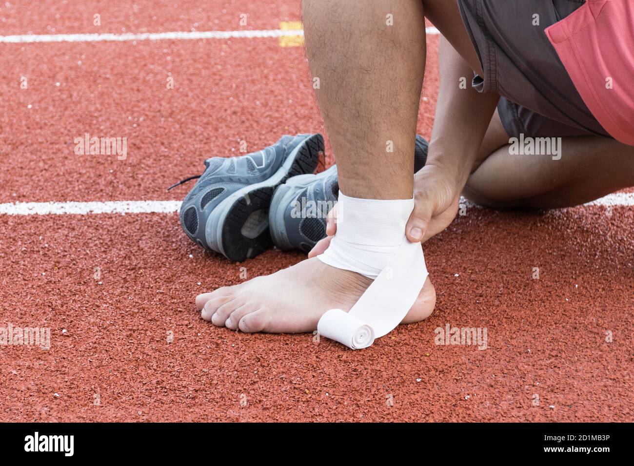 man applying compression bandage onto ankle injury After exercise