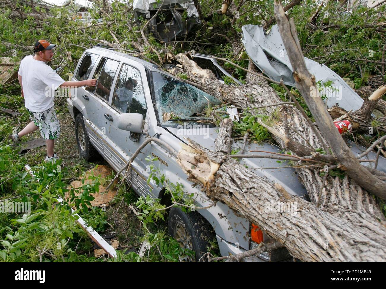Robert Dilka looks at his father-in-law's car smashed by a tornado in Windsor, Colorado May 22, 2008. Several tornados touched down in the area around lunchtime.  REUTERS/Rick Wilking (UNITED STATES) Stock Photo