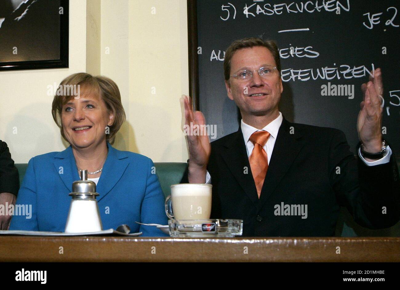 Conservative challenger Angela Merkel (L) leader of Germany's Christian Democratic Union (CDU) and Guido Westerwelle, leader of the German liberal Free Democratic Party (FDP) pose for photographers in a restaurant in the western German city of Bonn September 17, 2005. German Chancellor Gerhard Schroeder and his rival Angela Merkel launched a final drive on election eve on Saturday to win over up to 10 million undecided voters - estimated to be the highest total ever. REUTERS/Ina Fassbender  INA/AA Stock Photo