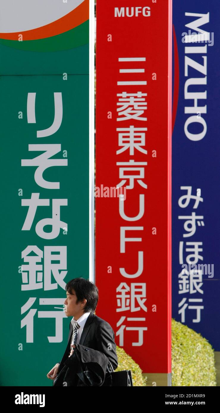 A Man Walks Past Signboards Of Banks In Tokyo December 8 09 Outstanding Loans Held By Japanese Banks Rose 0 2 Percent In November From A Year Earlier The Bank Of Japan Said