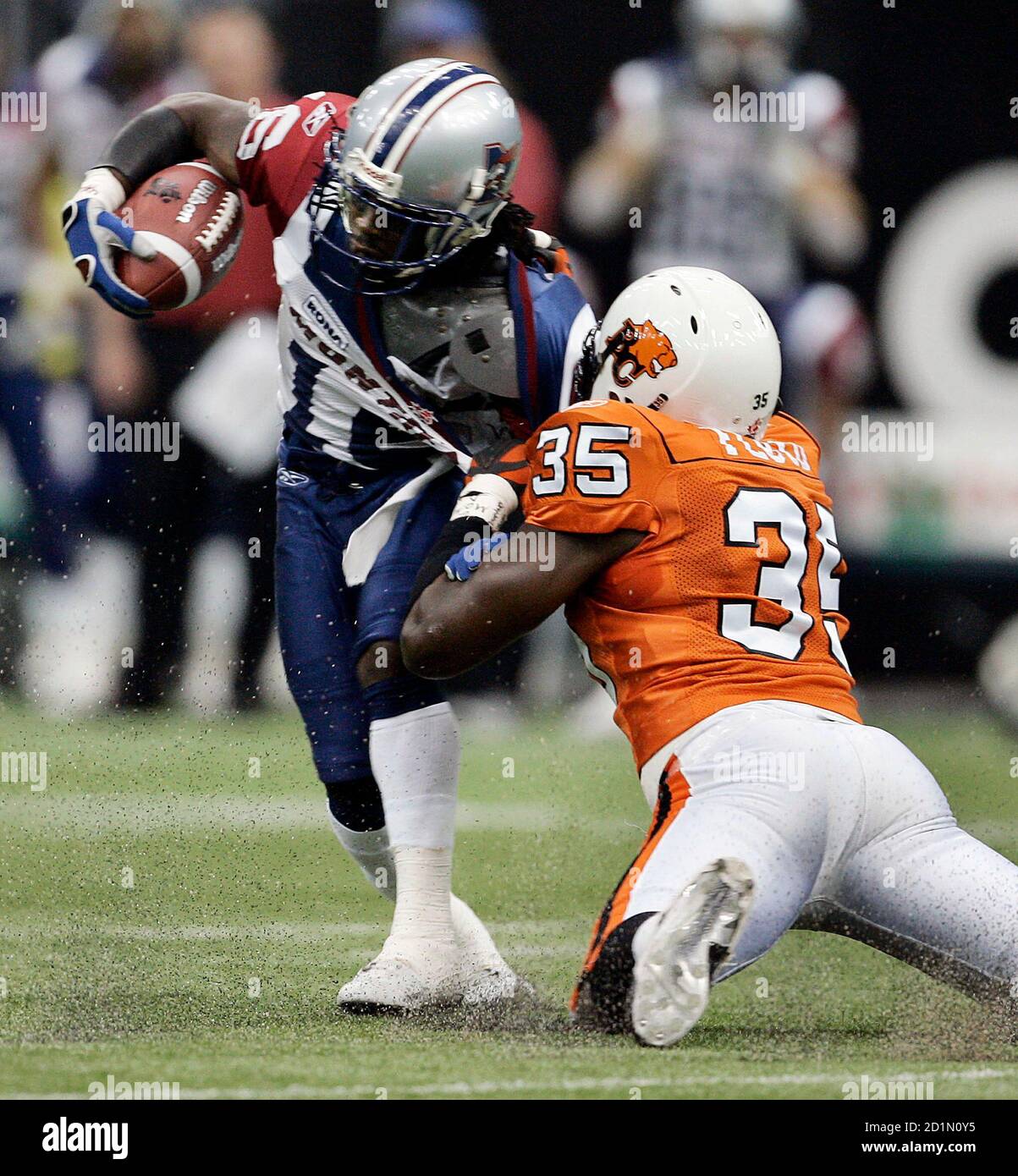 BC Lions linebacker Otis Floyd (R) grabs a hold of Montreal Alouettes' slotback Ezra Landry's sweater while trying to tackle him during first half Canadian Football League play in Vancouver, British Columbia, September 17, 2005. REUTERS/Andy Clark  AC/PN Stock Photo
