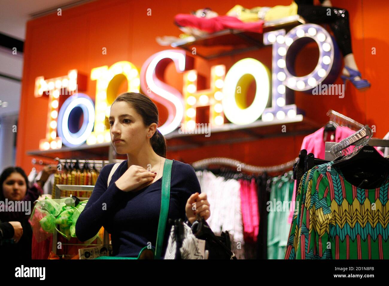 A woman looks at clothing items while shopping in the new Topshop and  Topman clothing store in New York April 2, 2009. Topshop, Britain's trendy  mass-market fashion retailer, could eventually have about