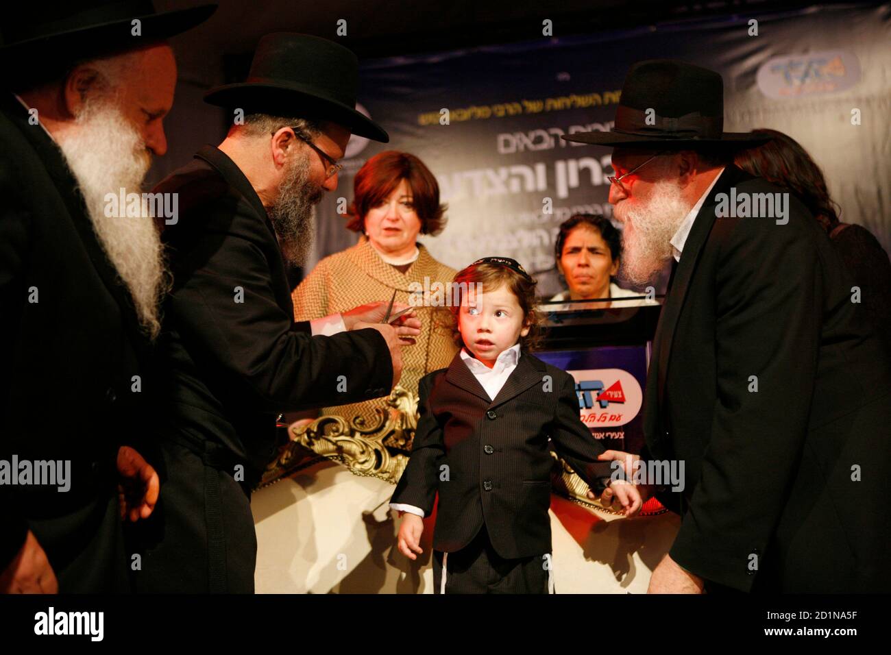 Ultra-Orthodox Jews cut the hair of Moishe Holtzberg during the Halake  ceremony in Kfar Chabad, near Tel Aviv, November 18, 2009. Moishe is the  son of Rabbi Gavriel Holtzberg and his wife