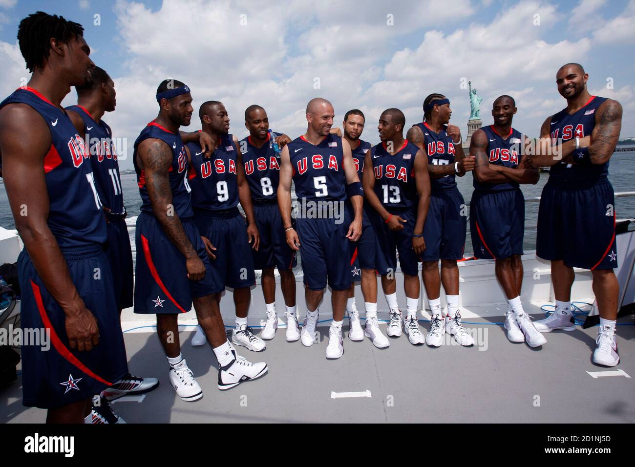 The U S Men S Olympic Basketball Team Pauses For Photographs As They Stand In Their Official Uniforms On The Top Deck Of A Tour Boat Near The Statue Of Liberty During A Promotional