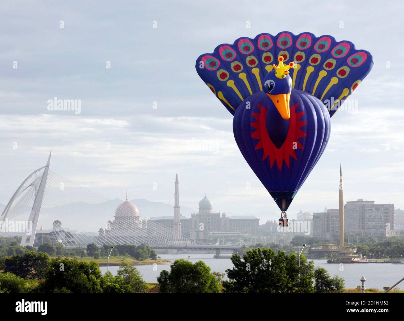 The hot air balloon of A. J. Troost named 'Peacock' from the Netherlands floats over Malaysia's landmarks Seri Wawasan Bridge (L), Putra Mosque (2nd L), Prime Minister's Office Putra Perdana (2nd R) and Millennium Monument Putrajaya, during International Hot Air Balloon Fiesta 2009 in Putrajaya outside Kuala Lumpur March 21, 2009. The four-day show ends on Sunday with participants from Belgium, New Zealand, Netherlands, France, United States, Philippines, Switzerland, Japan and Malaysia. REUTERS/Bazuki Muhammad (MALAYSIA SOCIETY) Stock Photo