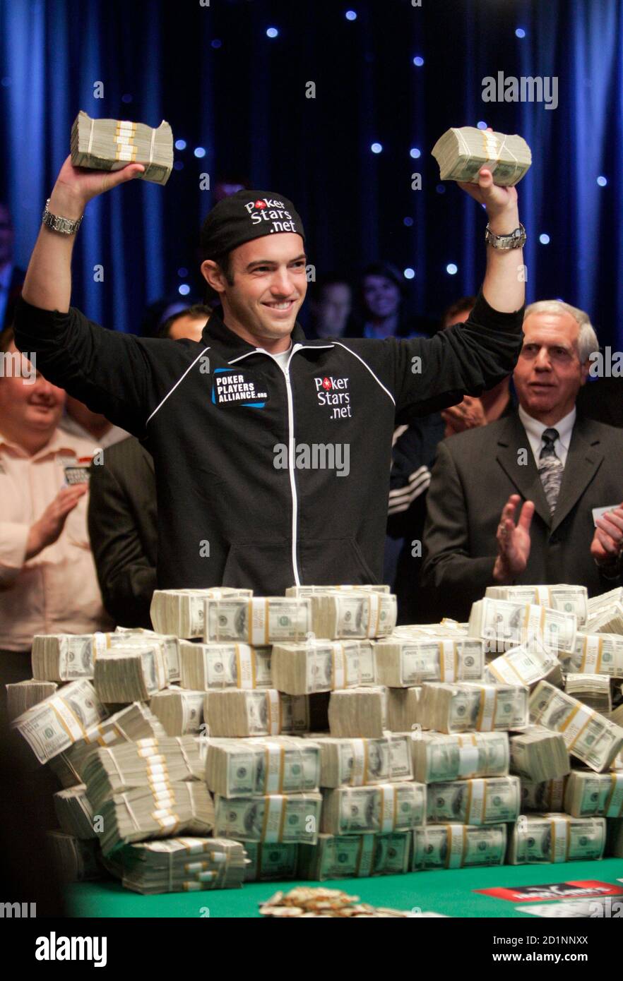 Joe Cada, a 21-year old poker professional from Michigan, celebrates with  bundles of cash after winning $8.5 million in prize money at the World  Series of Poker tournament at the Rio hotel-casino