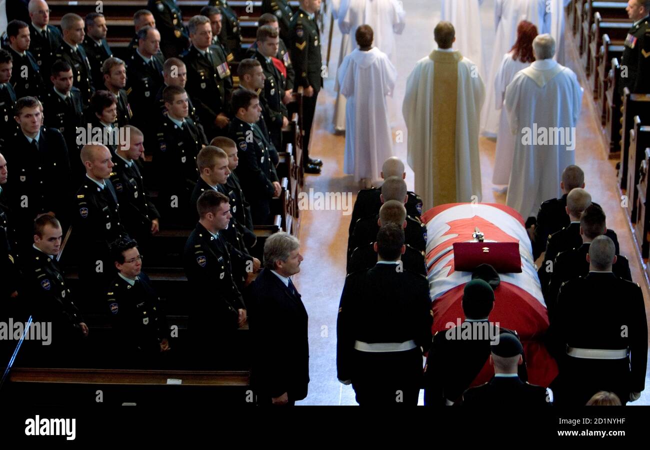 Soldiers watch as the casket of Private Simon Longtin is carried into a church for his funeral in Longueuil, Quebec August 27, 2007. Private Longtin, attached to the 22 Regiment based at Valcartier, Quebec, was killed on August 19, 2007 in Afghanistan when a roadside bomb detonated underneath the vehicle he was in.  Reuters/Christinne Muschi (CANADA) Stock Photo
