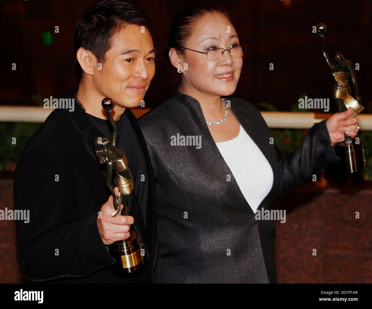 Chinese actor Jet Li and actress Si Qin Gao Wa pose their awards after winning the Best Actor and Best awards for their roles in 'The Warlords'and 'The Postmodern Life