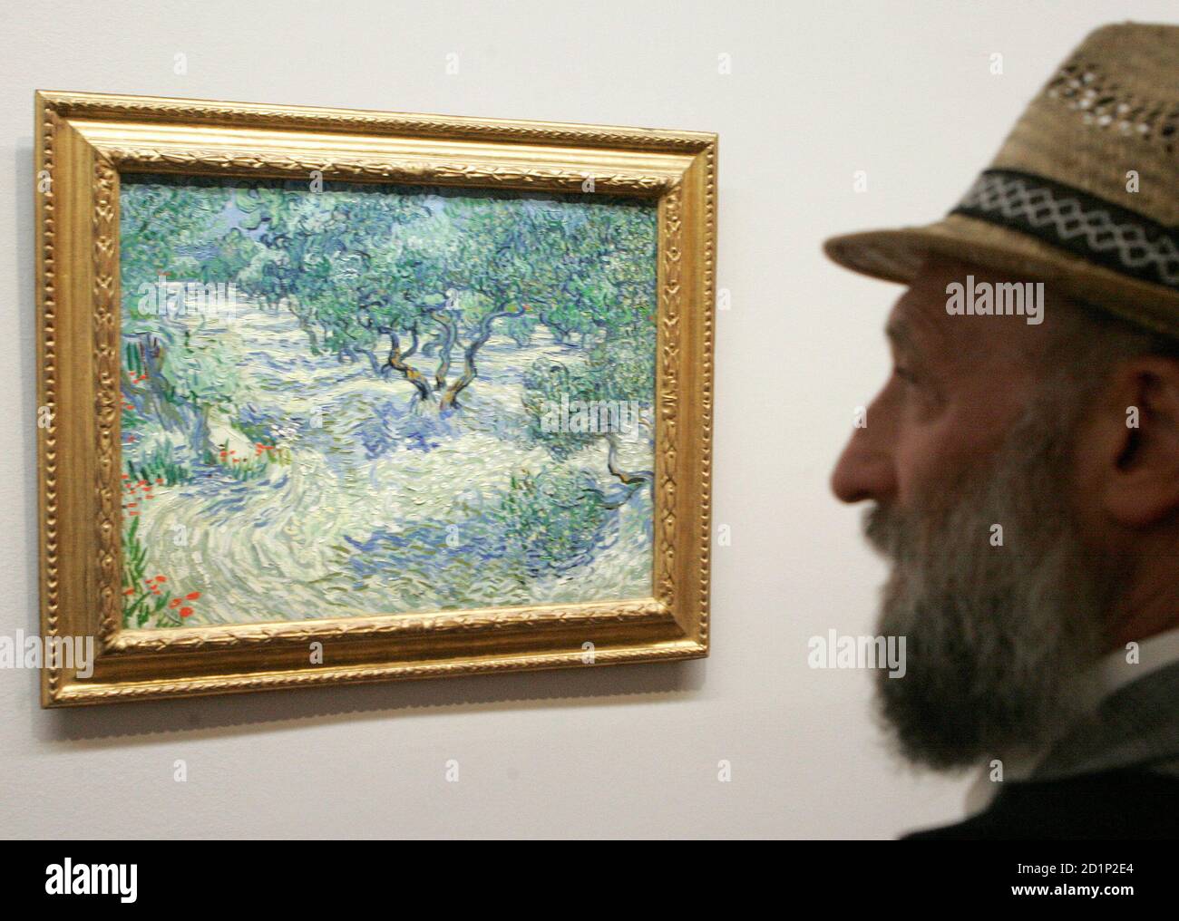 A visitor looks at a the painting "Olive Orchard" by Vincent Van Gogh  during the opening of an exhibition at the Albertina Museum in Vienna  September 3, 2008. REUTERS/Herwig Prammer (AUSTRIA Stock