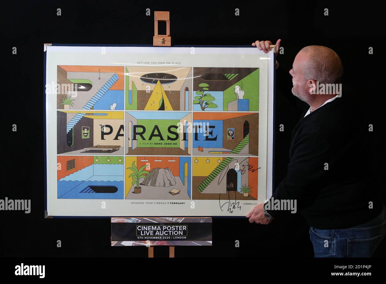 Prop Store poster consultant Mark Hochman looks at a UK quad poster by La Boca for the 2019 film 'Parasite' (estimate £500-700), autographed by the director Bong Joon-ho and star Song Kang Ho, during a preview for the forthcoming cinema poster auction by the Prop Store in Chorleywood, Hertfordshire. Stock Photo