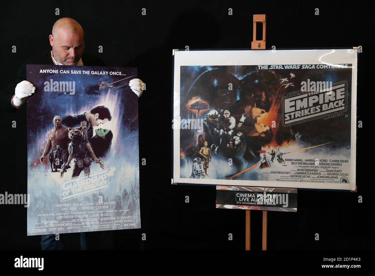 Prop Store poster consultant Mark Hochman holds a Mondo poster for the 2017 film 'Guardians of the Galaxy: Volume II' (estimate £300-500) next to a UK quad 'Gone With the Wind' Style poster for the 1980 film 'Star Wars: The Empire Strike Back' (estimate £2.5-3.5k) during a preview for the forthcoming cinema poster auction by the Prop Store in Chorleywood, Hertfordshire. Stock Photo