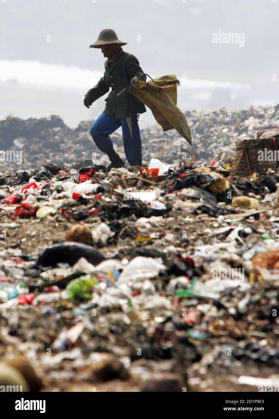 A garbage collector looks for waste to recycle at a garbage dump site in  Sanya, China's Hainan province, October 17, 2006. Growing populations and  booming economies are threatening fragile coastal areas in