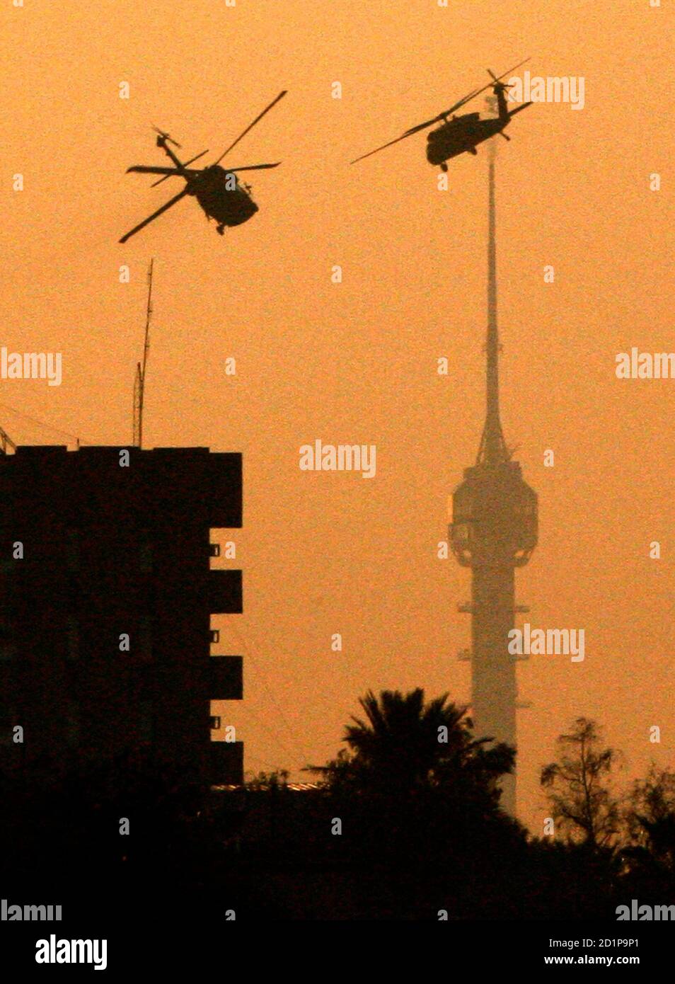 Two U.S. Black Hawk helicopters patrol over Baghdad during sunset November 30, 2006. REUTERS/Nikola Solic (IRAQ) Stock Photo