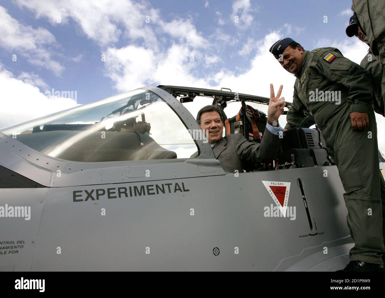 Colombia's Defense Minister Juan Manuel Santos gestures from a Tucano turboprop plane at Bogota's military airport of Catam in Bogota, December 14, 2006. Brazil delivered three military planes in Colombia in a move that Colombia's biggest rebel group characterized as meddling in its four-decade fight to establish a socialist state. The Super Tucano turboprop planes, made by Embraer, are part of a bigger order of 25 aircraft worth $235 million.  REUTERS/Jose Miguel Gomez         (COLOMBIA) Stock Photo
