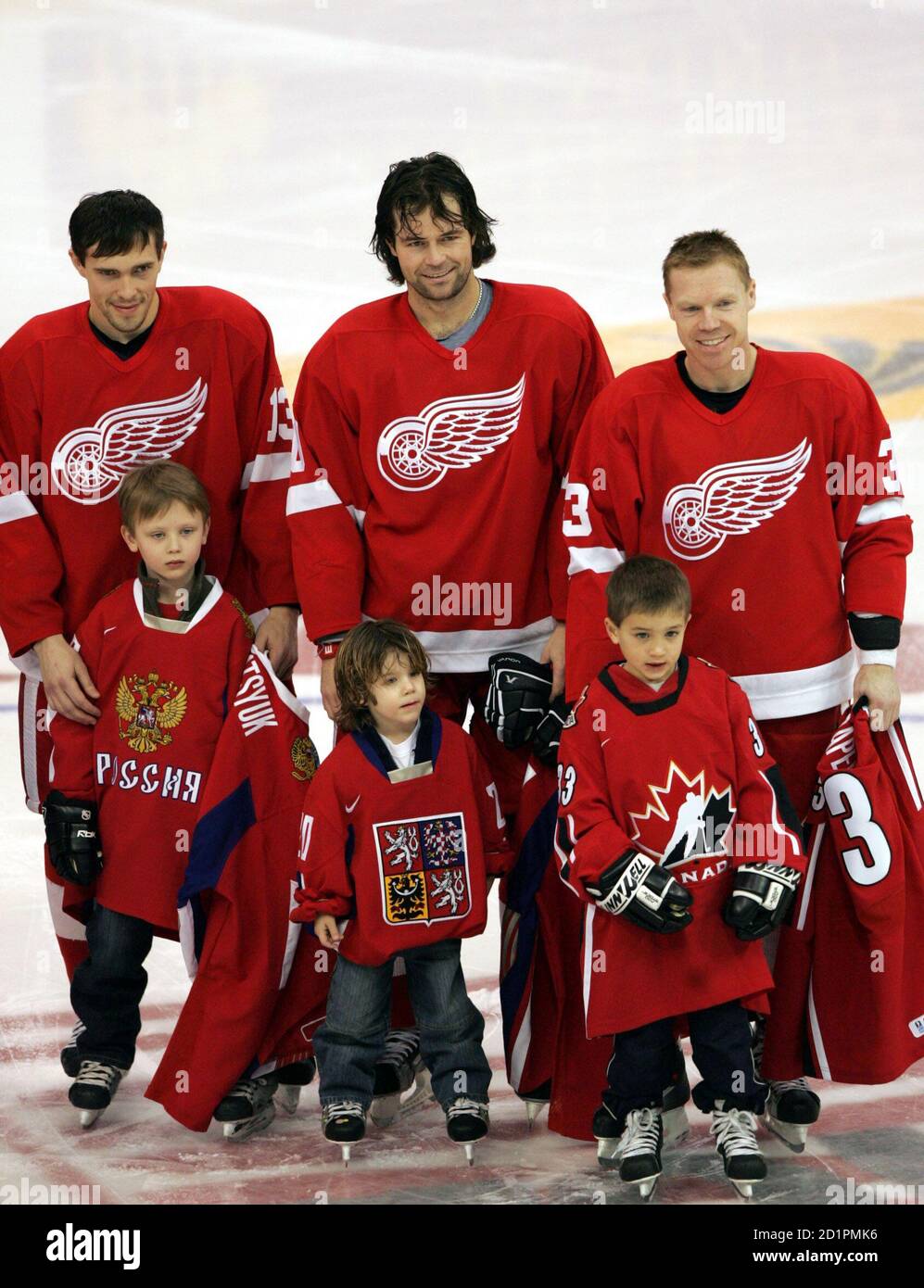 Winter Olympics-bound Detroit Red Wings' Kris Draper, representing Canada,  stands on the ice with child Jack Sanko as Draper is honored before the  start of the NHL game against the Colorado Avalanche