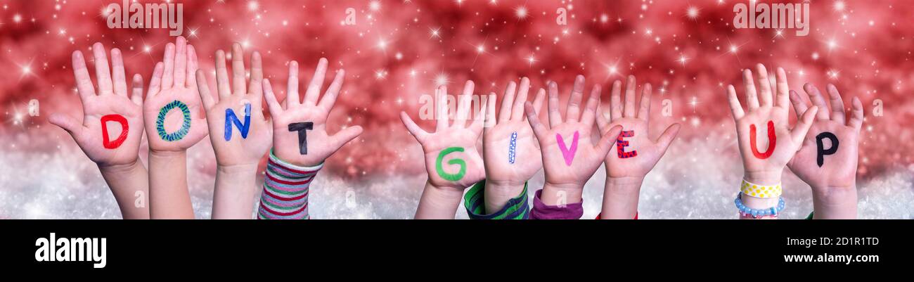 Children Hands Building Word Do Not Give Up, Red Christmas Background Stock Photo
