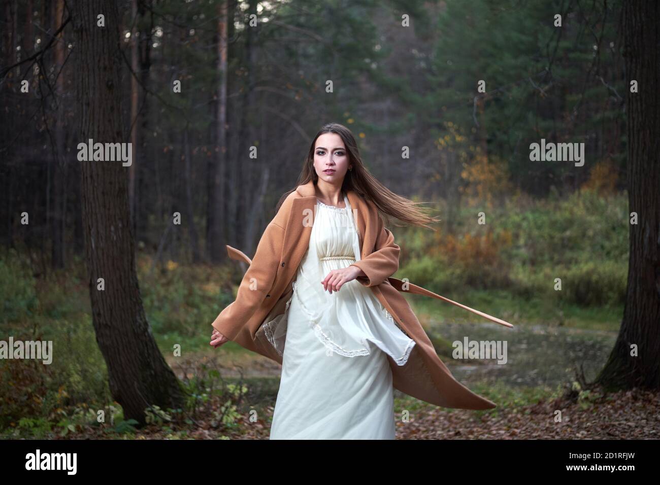 girl in a white dress and a brown coat in the autumn forest Stock Photo ...