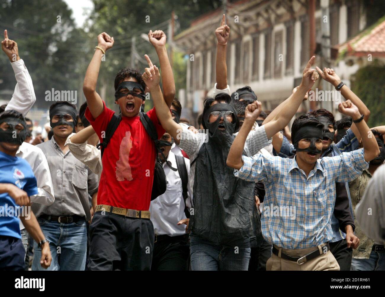 Nepali students shout anti-monarchist slogans while demanding reduction in price of petroleum products in Kathmandu.  Nepali students shout anti-monarchist slogans while demanding a reduction in the price of petroleum products in Nepal's capital Kathmandu August 28, 2005. Students from several campuses belonging to seven political parties took party in a protest rally, wearing black masks. REUTERS/Gopal Chitrakar Stock Photo