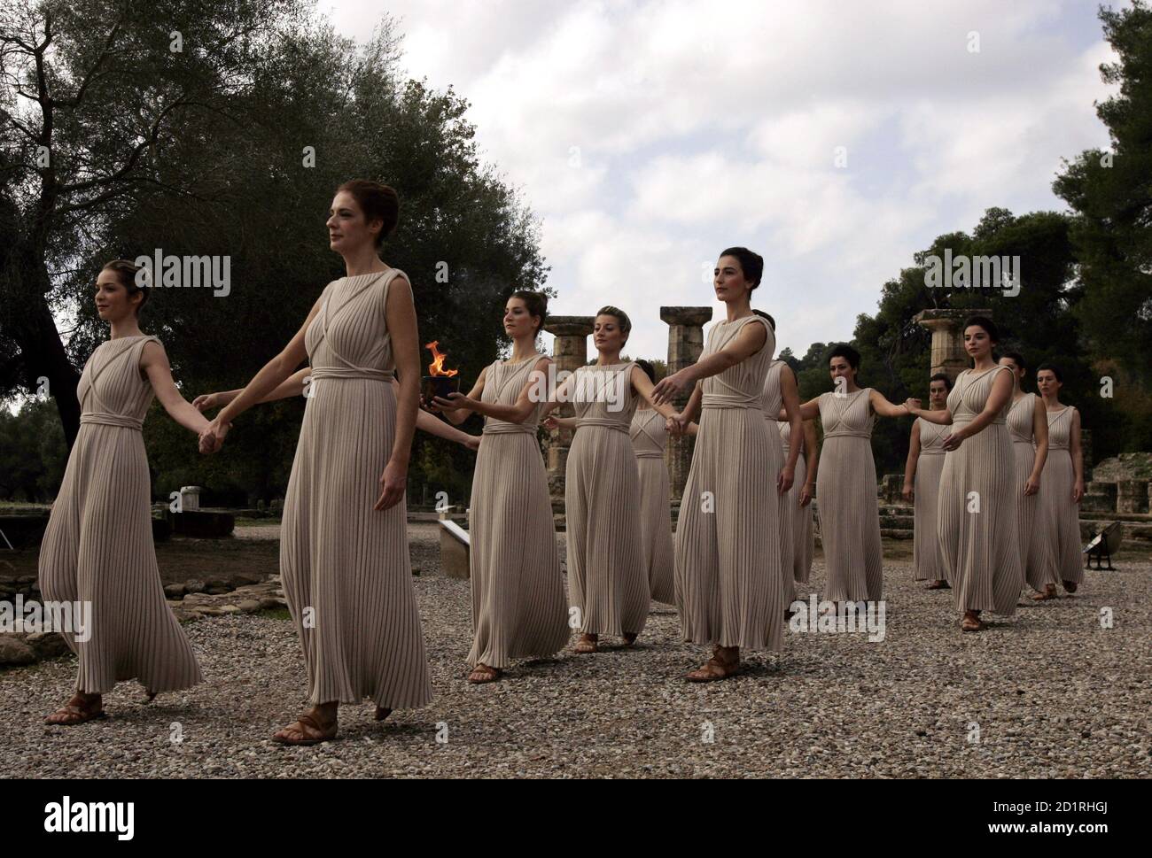 A group of white-robed priestesses carry the Olympic flame in a replica of  an ancient Greek pot during a ceremony in front of the Temple of Hera in  ancient Olympia November 27,