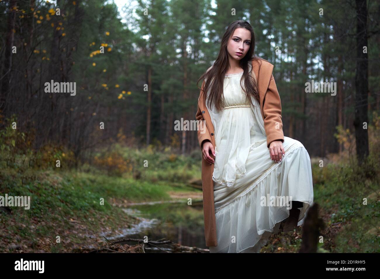 girl in a white dress and a brown coat in the autumn forest Stock Photo ...