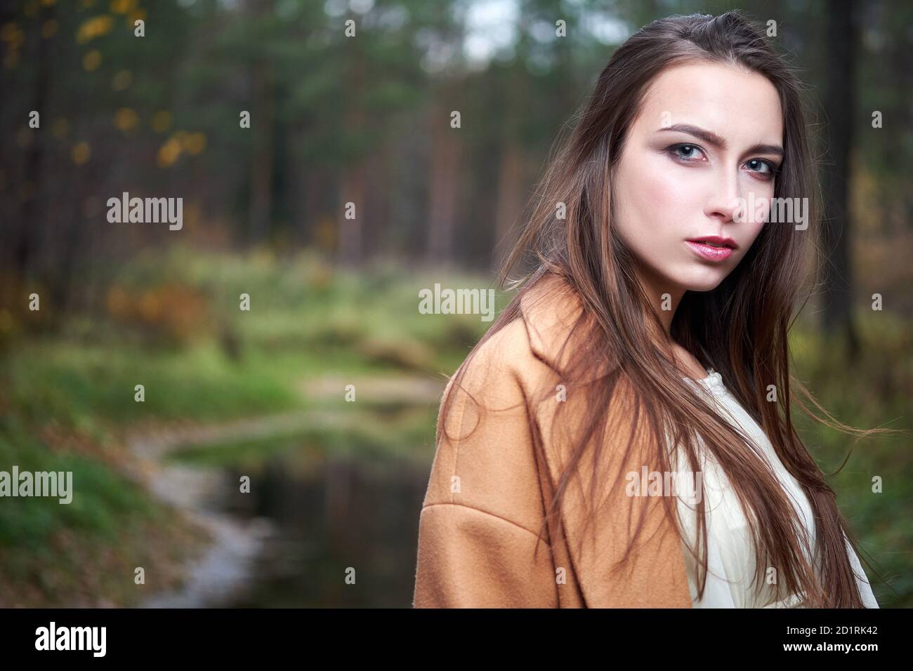 girl in a white dress and a brown coat in the autumn forest Stock Photo ...