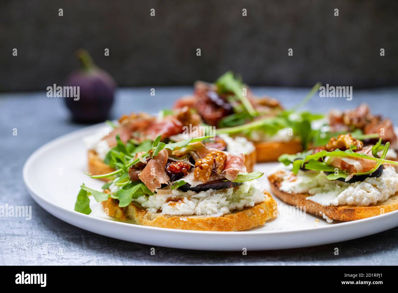 Canapes with ricotta cheese, figs, walnuts and parma ham Stock Photo