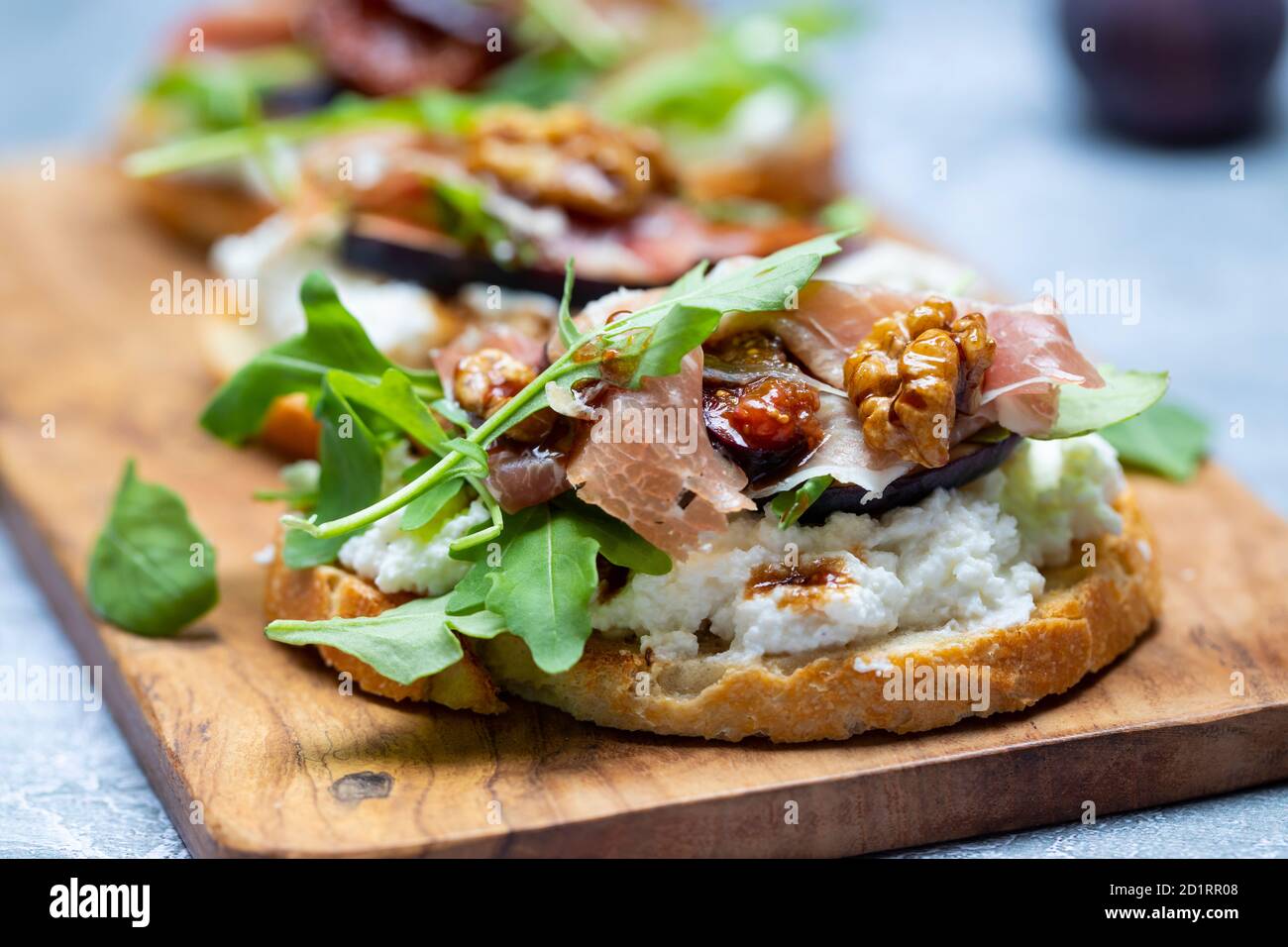 Canapes with ricotta cheese, figs, walnuts and parma ham Stock Photo