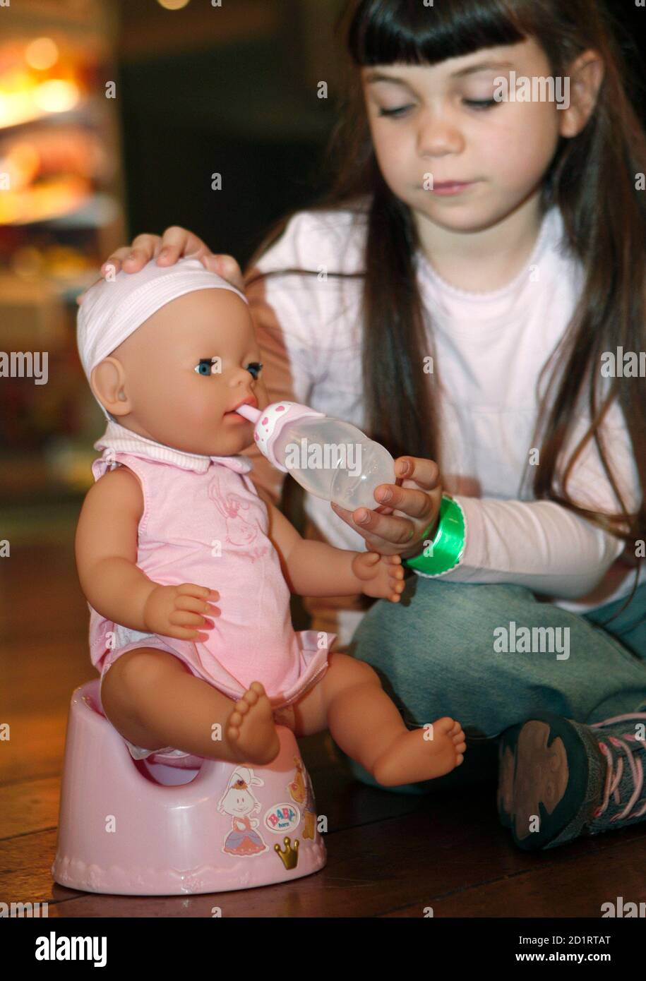 A girl poses with the "BABY born with Magic Potty" toy at the Dream Toys  exhibition in London October 15, 2008. The Toy Retailers Association  predicts the toy to be one of