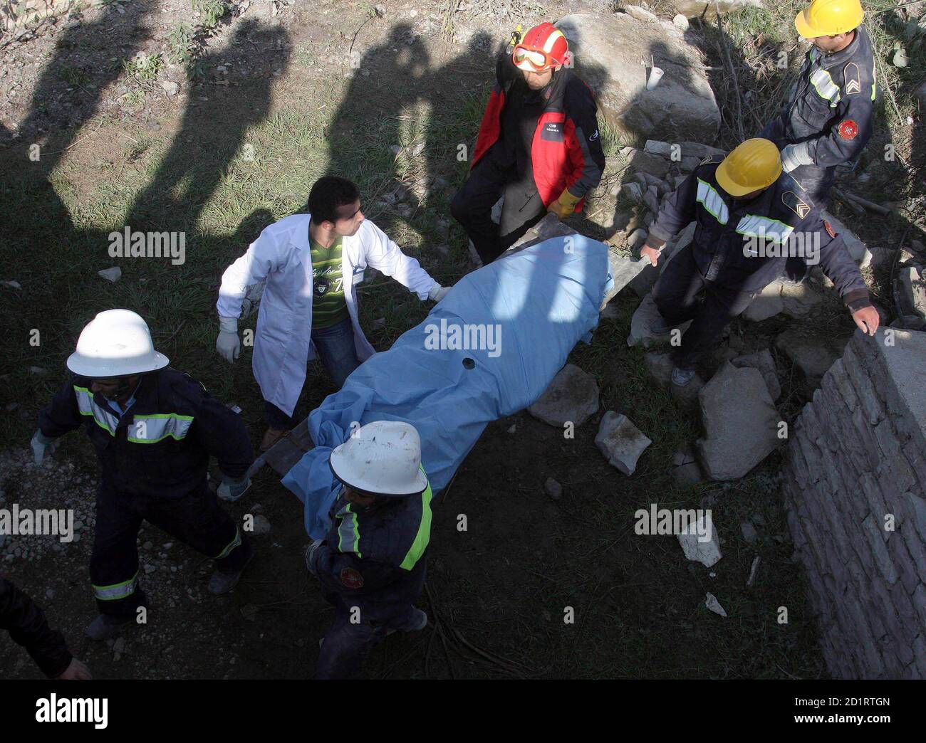Albanian firefighters carry the body of 65-year-old Parashqevi Zoto after removing her from the rubble of a collapsed apartment building in Gjirokaster, some 250 km (156 miles) south of Tirana near the Greek border, November 10, 2008. Zoto and a young mother and her daughter were trapped when the six-storey building collapsed on Sunday, injuring four people, according to local media. REUTERS/Arben Celi (ALBANIA) Stock Photo