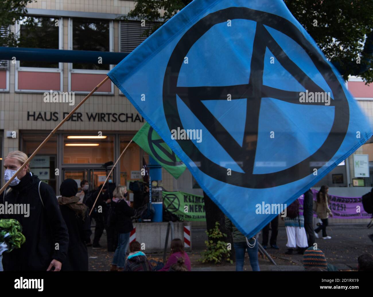 Berlin, Germany. 06th Oct, 2020. Participants of a protest action of the environmental protection alliance Extinction Rebellion (XR) demonstrate in front of the Haus der Wirtschaft in the Berlin district Charlottenburg and hold flags with the XR logo. Activists have penetrated the office building. The police are on site with a large contingent. Credit: Paul Zinken/dpa/Alamy Live News Stock Photo