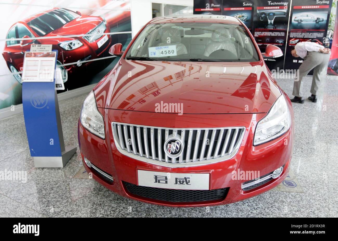 A customer looks at a Buick Regal car at a General Motors auto dealership in Shanghai May 29, 2009. GM is facing imminent bankruptcy in the United States after bondholders rejected a debt-for-equity swap, a key part of the restructuring plan it needs to complete before a June 1 deadline imposed by the administration of President Barack Obama. Its China division, primarily two ventures with SAIC Motor, is profitable and self-sufficient, and able to fund its own daily operations and expansion, executives say. REUTERS/Aly Song (CHINA TRANSPORT BUSINESS) Stock Photo