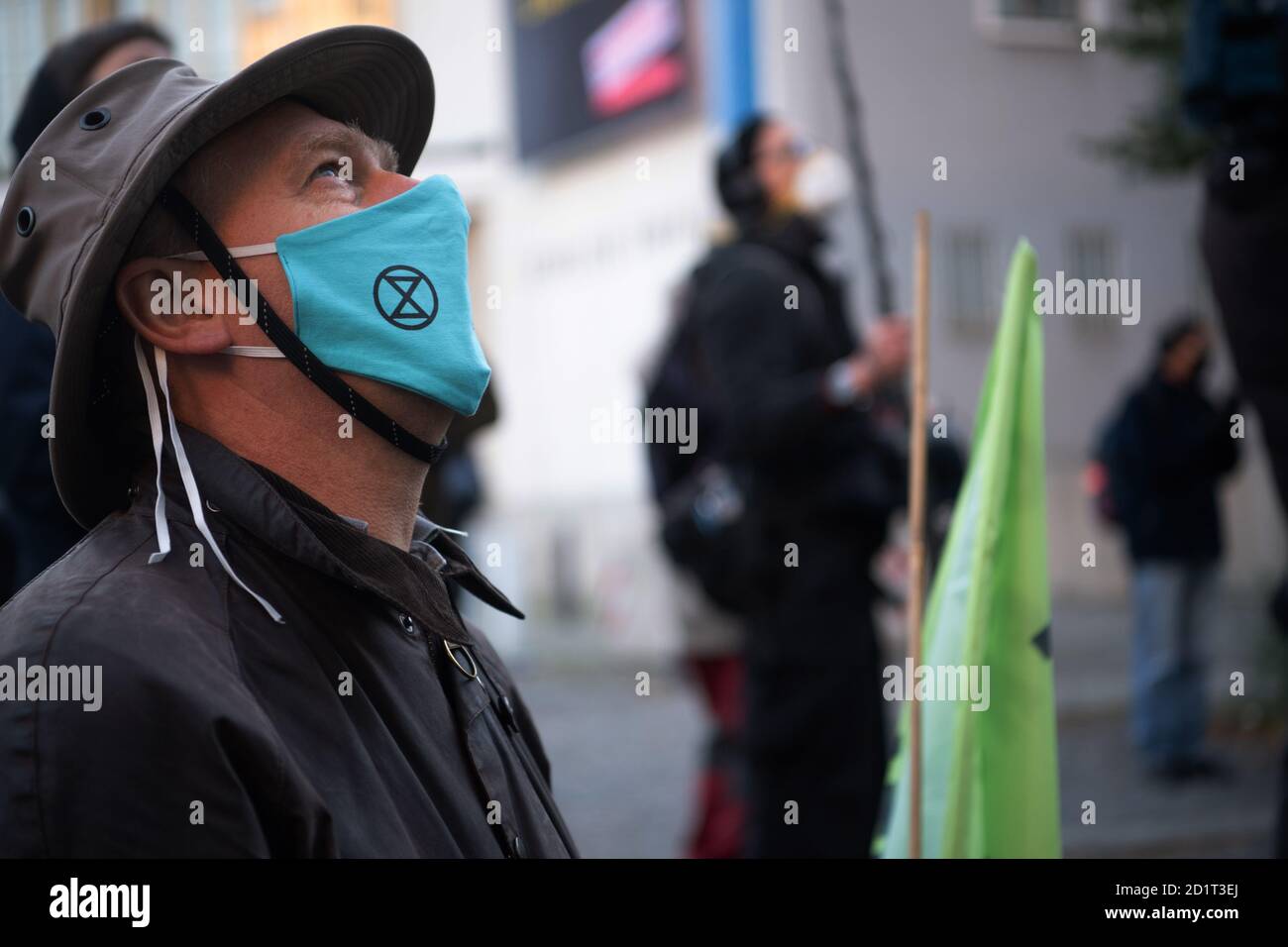 Berlin, Germany. 06th Oct, 2020. A participant of a protest action of the environmental protection alliance Extinction Rebellion (XR) stands with a mouth guard with XR logo in front of the Haus der Wirtschaft in the Berlin district Charlottenburg, where activists block the street in front of the building. Credit: Paul Zinken/dpa/Alamy Live News Stock Photo