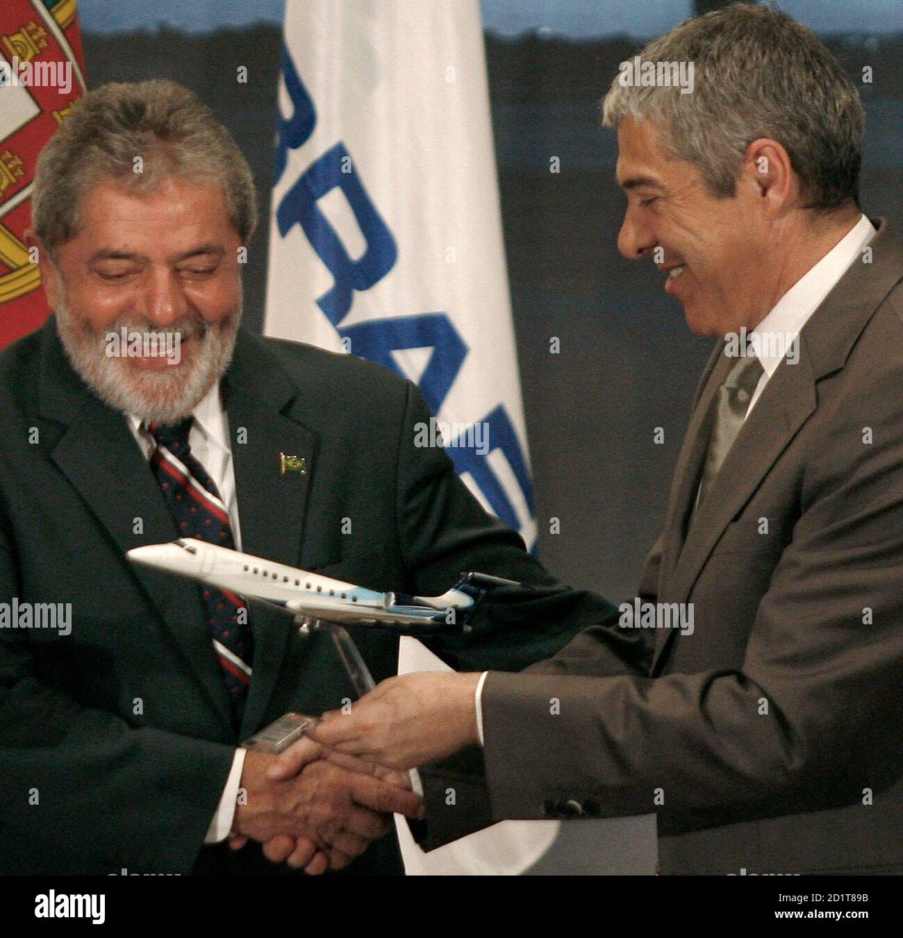 Brazil's President Luiz Inacio Lula da Silva (L) shakes hands with Portugal's Prime Minister Jose Socrates after a cooperation agreement in Lisbon July 26, 2008. Brazil's Embraer, the world's third-biggest commercial jet maker, said on Saturday it would invest 148 million euros in two components plants in Portugal to expand its operation in Europe, now mainly focused on aircraft servicing. REUTERS/Nacho Doce (PORTUGAL) Stock Photo