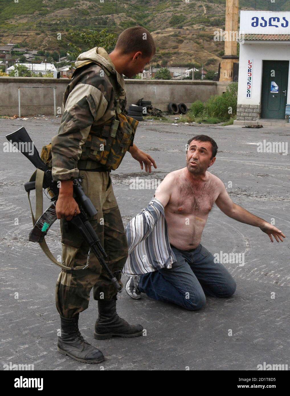 Russian soldiers detain a man who carried a weapon in his car at a checkpoint in the Georgian city of Gori, near South Ossetia, August 14, 2008. Russian President Dmitry Medvedev pledged support on Thursday for two separatist regions fighting for independence from Georgia, as Washington demanded that the war-torn country's territorial integrity be respected. REUTERS/Gleb Garanich (GEORGIA) Stock Photo
