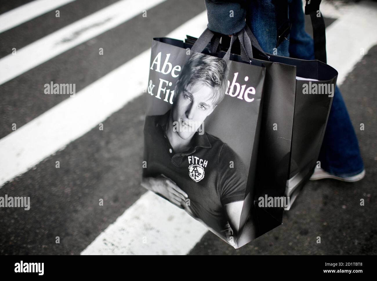 A man holds shopping bags from retailer Abercrombie & Fitch while waiting  to cross a street in New York October 8, 2009. U.S. retailers posted their  first monthly sales increase in more