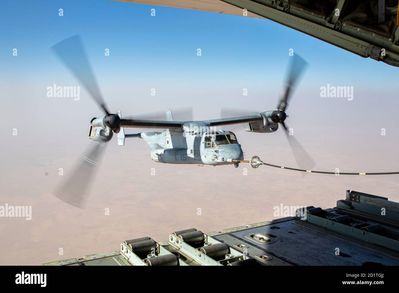 A U.S. Marine Corps MV-22 Osprey with Marine Medium Tiltrotor Squadron 166, Special Purpose Marine Air-Ground Task Force – Crisis Response – Central Command, receives fuel from a U.S. Marine Corps KC-130 during an air-to-air refueling (AAR) mission over the U.S. Central Command Area of Responsibility on Oct. 3, 2020. The purpose of an AAR mission is to transfer aviation fuel from one aircraft to another in order to extend the range, payload capacity, and endurance of the receiving aircraft. The SPMAGTF-CR-CC is a crisis response force, prepared to deploy a variety of capabilities across the re Stock Photo