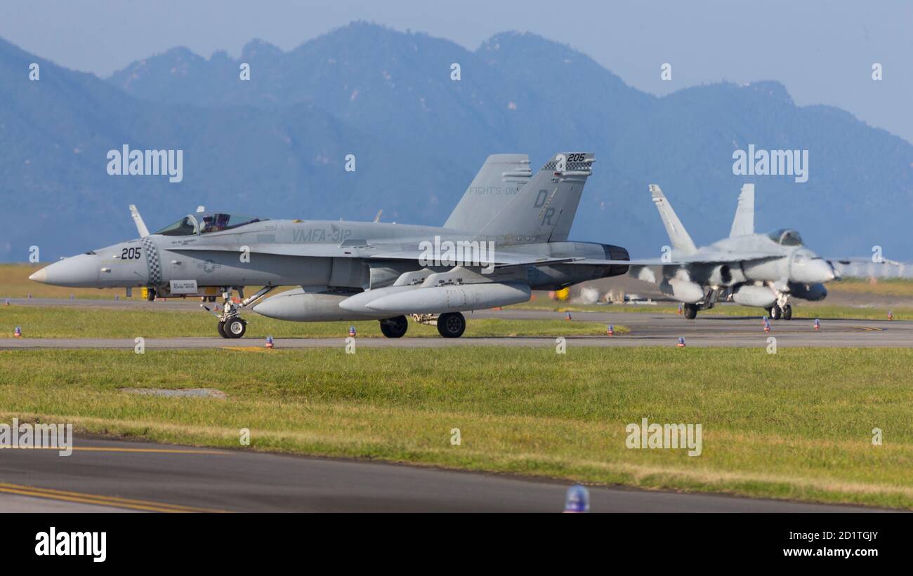 U.S. Marine Corps F/A-18C Hornets with Marine Fighter Attack Squadron (VMFA) 312 taxi the runway at Marine Corps Air Station Iwakuni, Japan, Oct. 2, 2020. Marines with VMFA - 312 and Marine All Weather Fighter Attack Squadron (VMFA (AW)) 533, based out of Marine Corps Air Station Beaufort, South Carolina, take part in a rotational unit deployment program to supplement Marine Aircraft Group (MAG) 12. The deployment enables MAG-12 to maintain its obligation to the Treaty of Mutual Cooperation and Security between Japan and U.S. while facilitating the safe transition for VMFA (AW) - 242 from F/A- Stock Photo