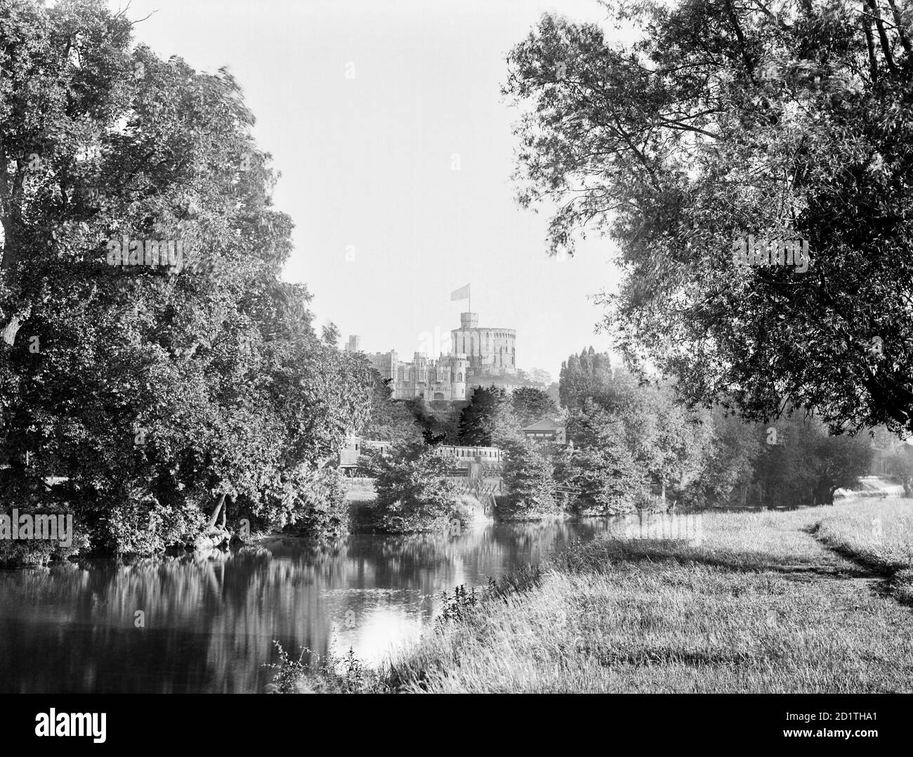 WINDSOR CASTLE, Berkshire. A view of the castle from above Romney Lock. Although William the Conquerer had a castle on this site, the first stone buildings were put up by Henry II between 1165 and 1179. The raised flag suggests Queen Victoria was in residence at the time. Photographed in 1888 by Henry Taunt. Stock Photo