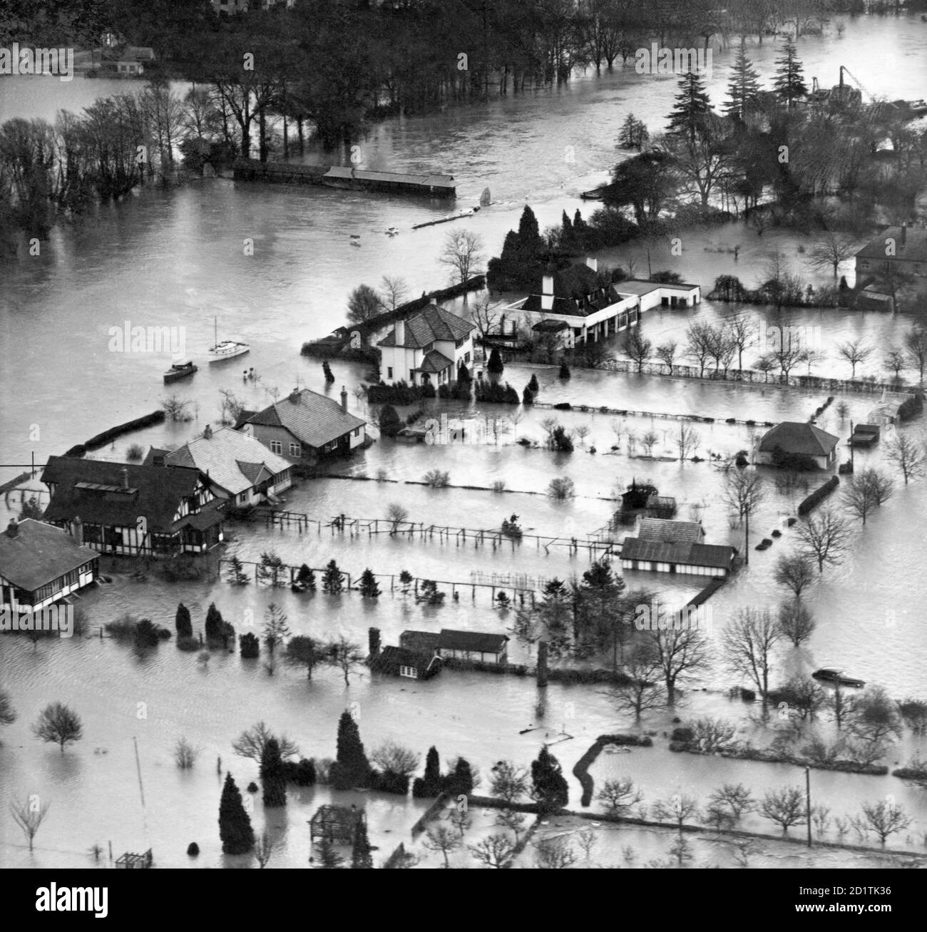 Boats are the best way of getting around by river, road or garden. Aerial view. Thames flooding in the Windsor area - probably Sunnymeads (SU997 749). 1947. Aerofilms Collection. Stock Photo