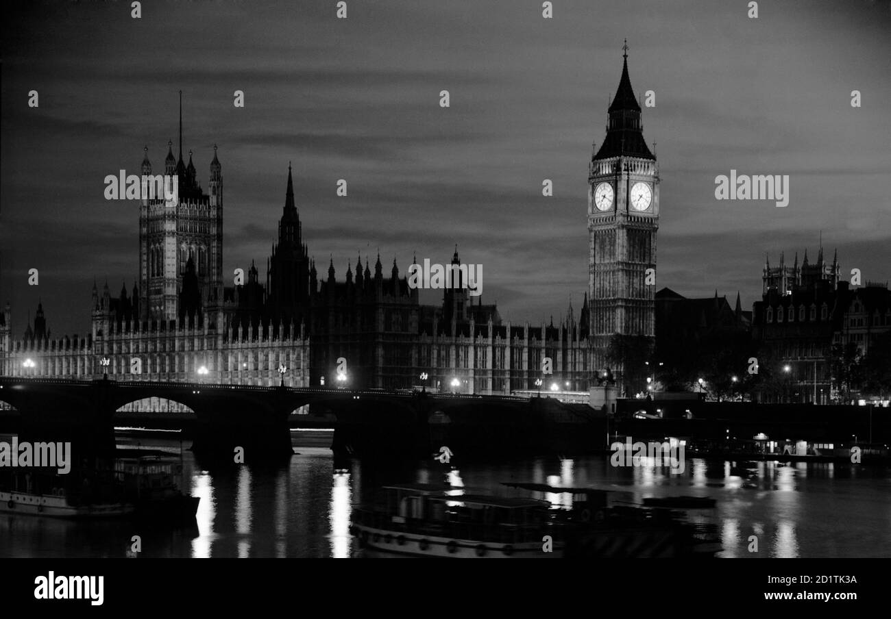PALACE OF WESTMINSTER, London. A view of the Houses of Parliament, including the 'Big Ben' clock tower, from the River Thames at night. Photographed by Eric de Mare. Date range: 1945-1980. Stock Photo