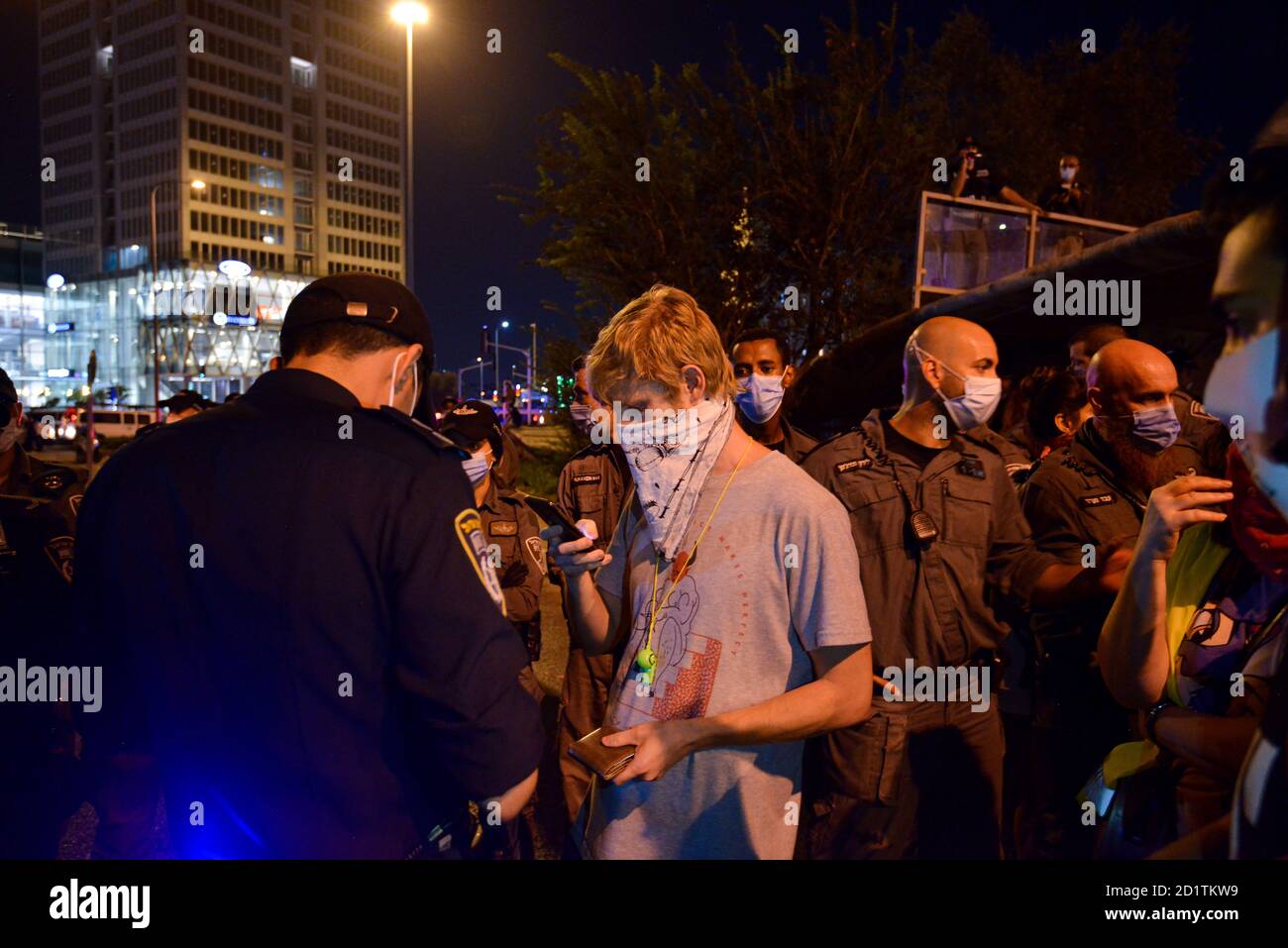 2.10.2020 Tel Aviv, Israel. Protest against Prime minister Netanyahu and second Coronavirus lockdown. Protestor getting a fine for not keeping 2m distance in the police corral. Stock Photo
