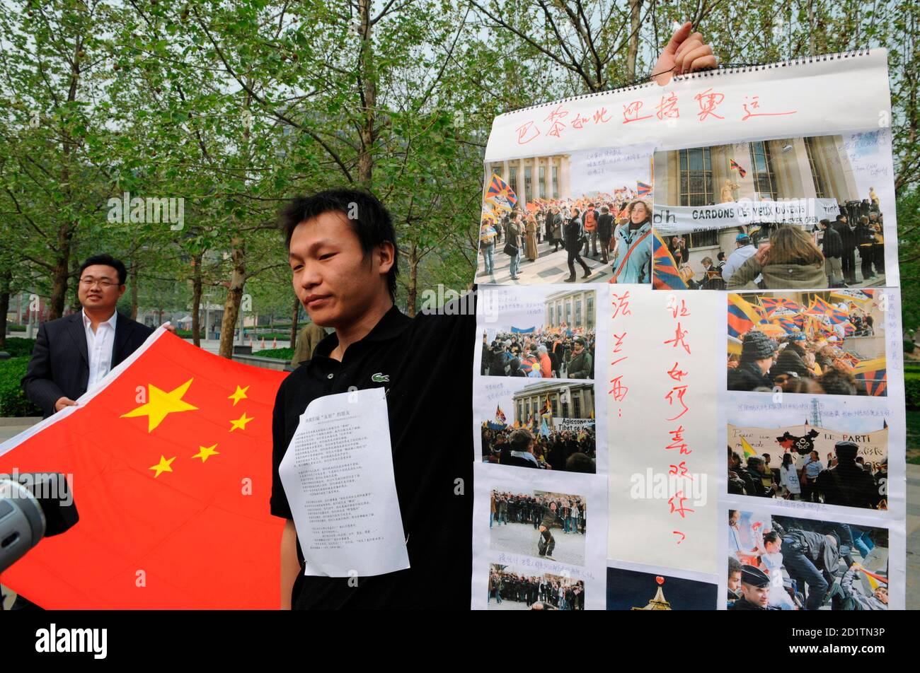 Lu Jixin holds a poster outside a branch of French hypermarket Carrefour in Beijing April 19, 2008 to demonstrate against the disruption of the Olympic torch relay in Paris. The messages on the poster read: 'This is how Paris welcomes the Olympics' and 'France: How can I like you?'. REUTERS/Joe Chan   (CHINA) Stock Photo