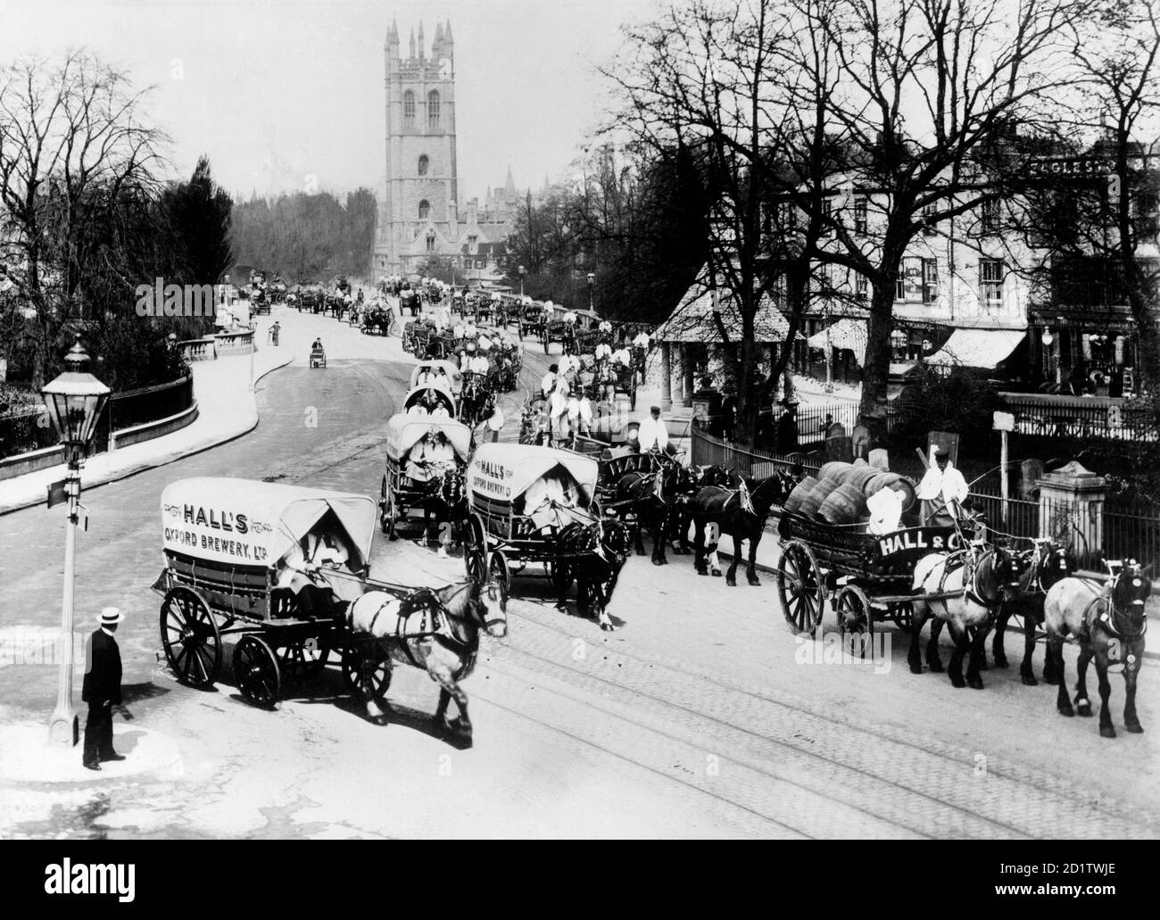 MAGDALEN BRIDGE, Oxford, Oxfordshire. The Hall's Brewery drays at front of the Oxford May Day processions in 1912. The procession has just passed over Magdalen Bridge and the 15th-century tower can be seen in the background. Photographed by Henry Taunt in May 1912. Stock Photo