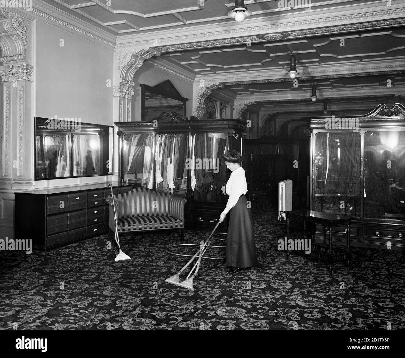 FREDERICK GORRINGE'S DEPARTMENT STORE, 75 Buckingham Palace Road, London. Interior view. A lady demonstrating the latest in vacuum cleaning technology. Gorringe's had opened in the 1900s, finally closing its doors in the 1960s.  Photographed by Bedford Lemere & Co in 1910. Stock Photo
