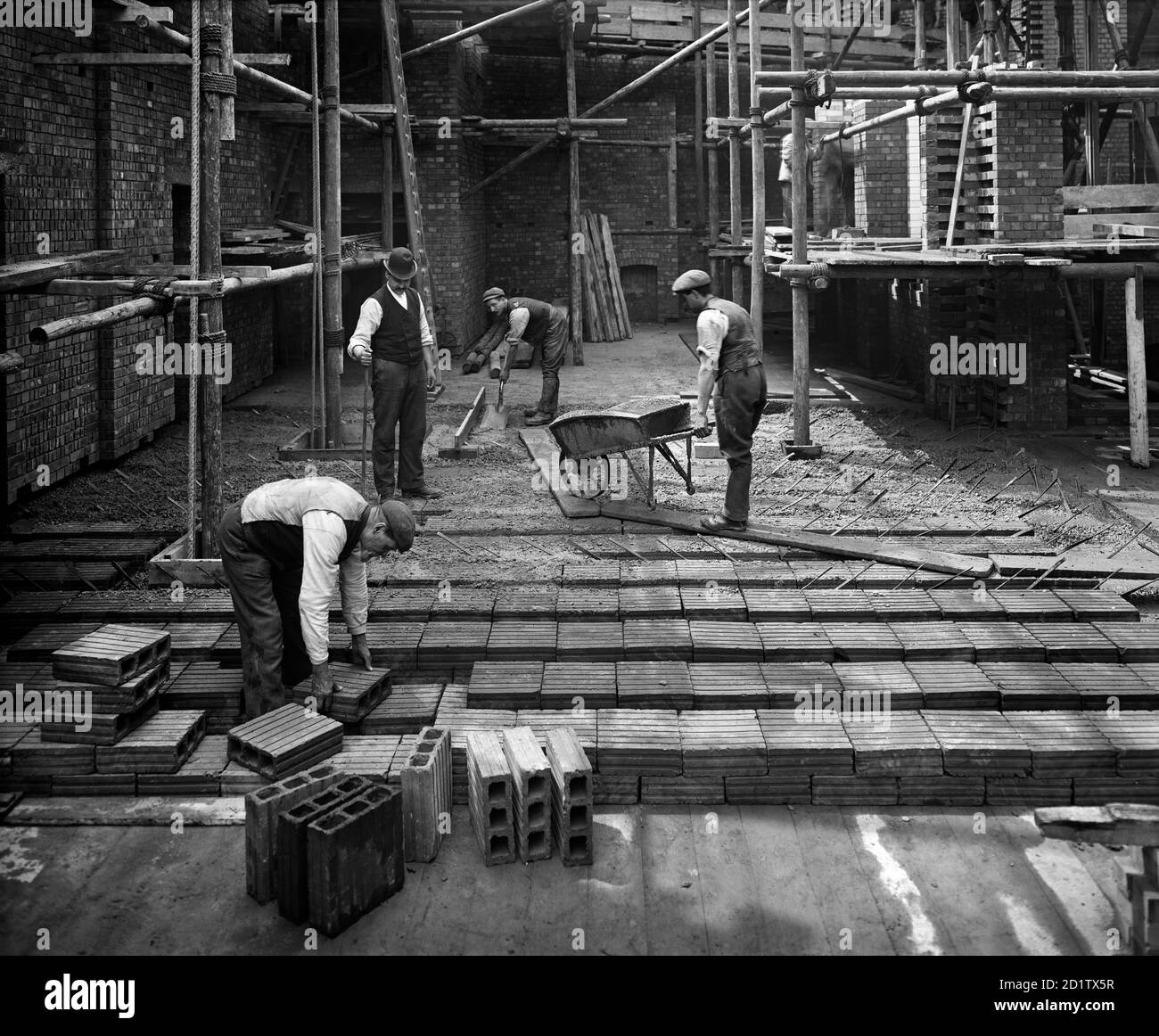 8 LLOYDS AVENUE, City Of London. Construction workers laying a 'hollow pot' reinforced concrete floor at number 8 Lloyds Avenue. The 'hollow pot' system, known as the Kahn system, was invented by Julius Kahn in 1903 and was much used for flooring. This building was designed by Richard Norman Shaw for Associated Portland Cement Manufacturers. Photographed by Bedford Lemere and Co. in 1907. Stock Photo